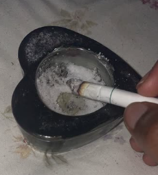 Picture of a cigarette in a heart shaped ashtray.